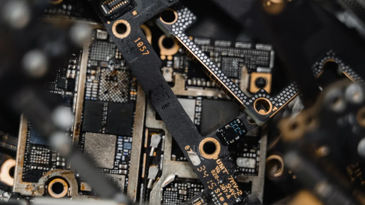 A collection of electronic circuit boards and components, including microchips, capacitors, and wires, with some of the components appearing