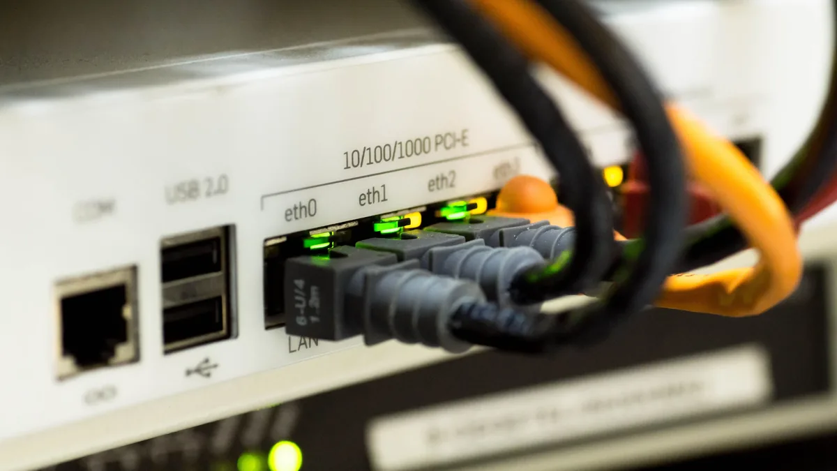 A close-up view of a network switch with cables plugged into it.